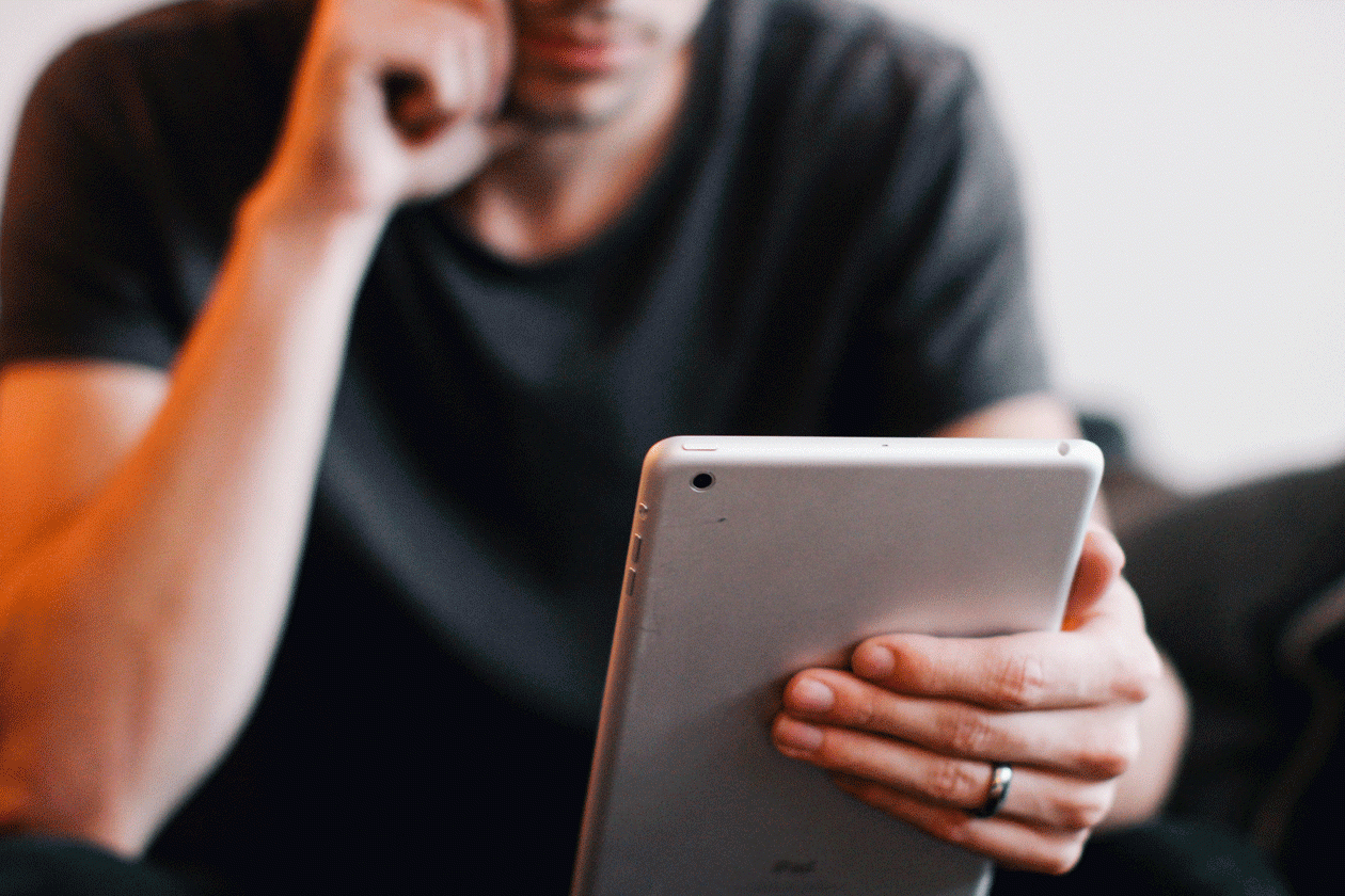 άντρας βλέπει βίντεο σε οθόνη που κρατάει στα χέρια του